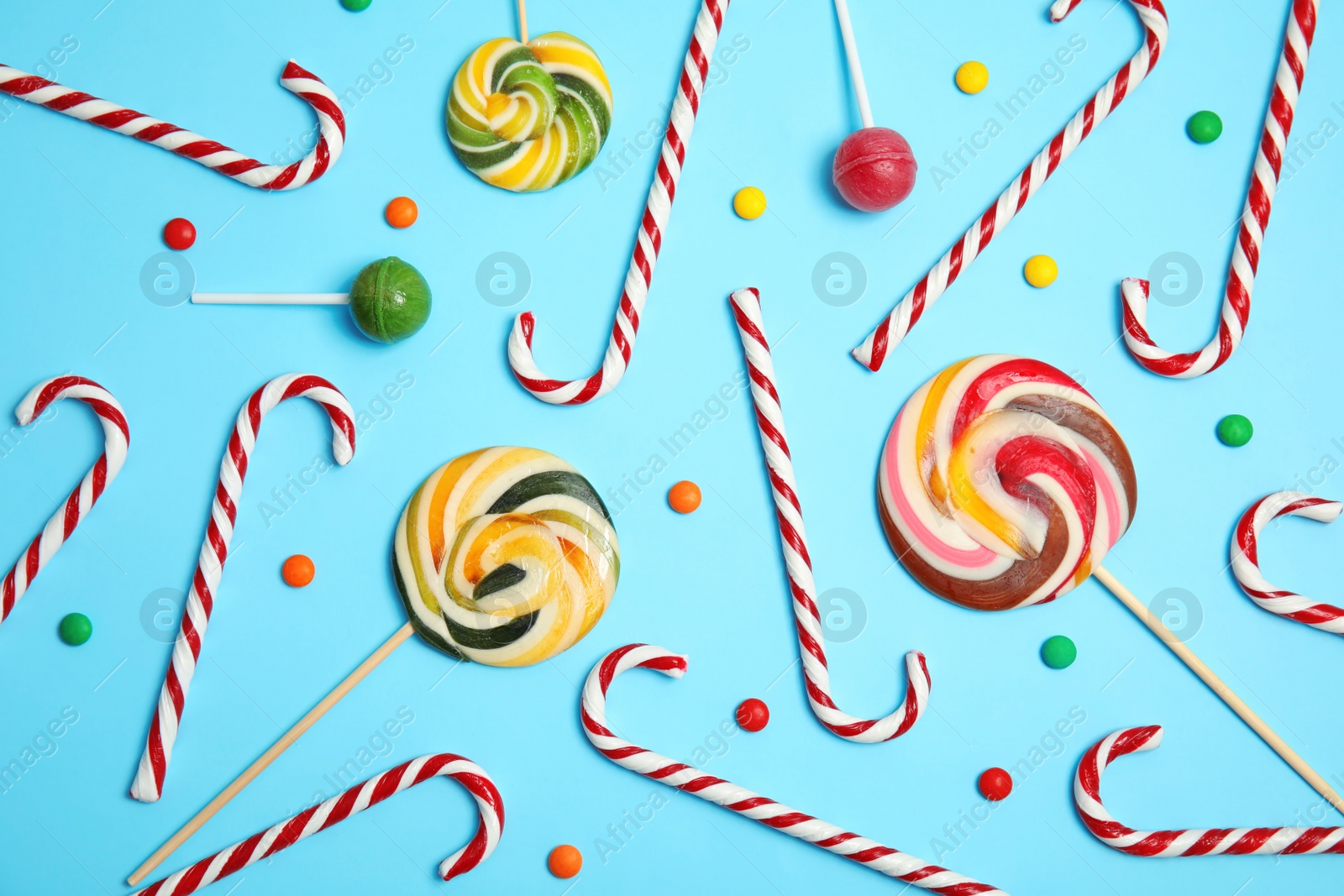 Photo of Flat lay composition with tasty candy canes on color background