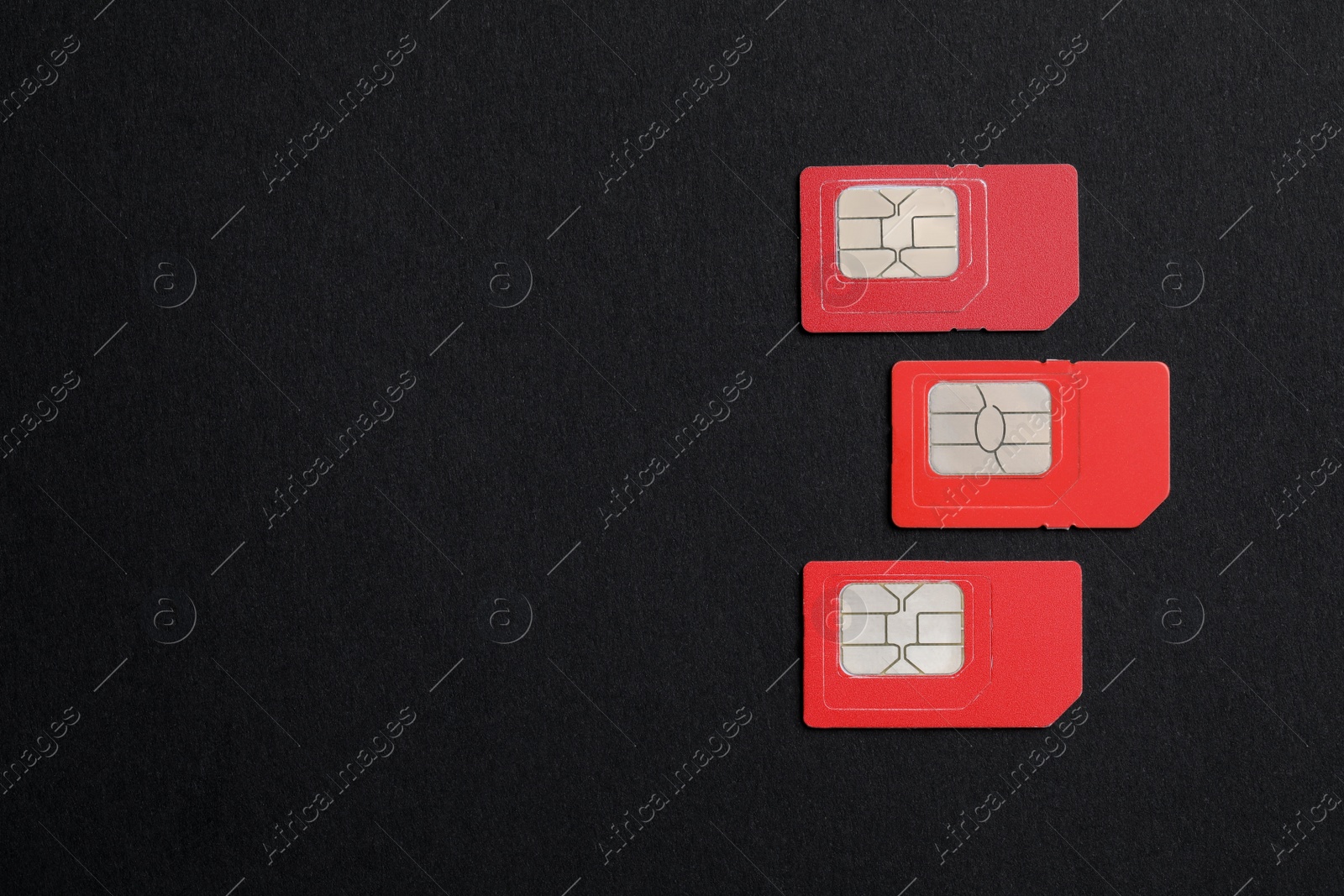 Photo of Red SIM cards on black background, flat lay. Space for text