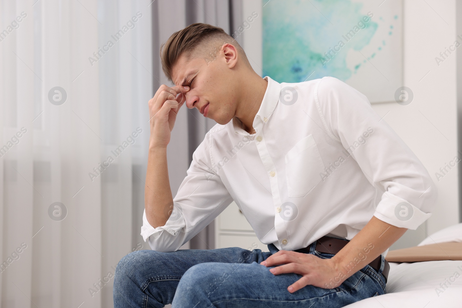 Photo of Overwhelmed man sitting on bed at home