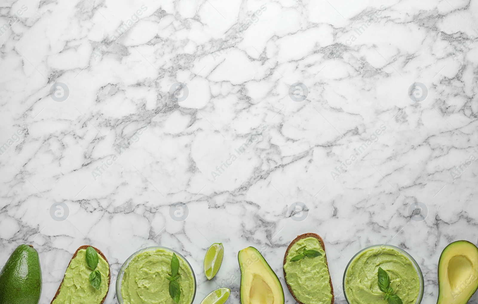 Photo of Flat lay composition with guacamole, sandwiches and avocados on white marble table. Space for text
