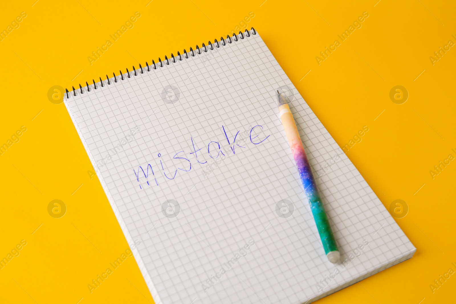 Photo of Word Mistake written with erasable pen in notepad on yellow background, closeup