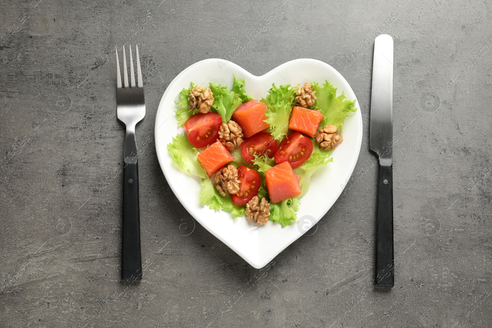 Photo of Plate with salad on grey background, flat lay. Heart-healthy diet