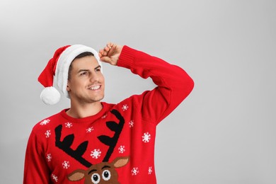Photo of Handsome man wearing Santa hat on grey background