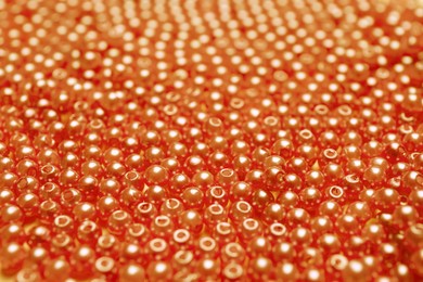 Image of Many bright orange beads as background, closeup