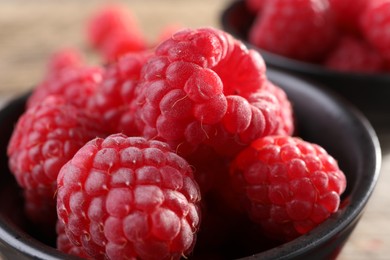 Tasty ripe raspberries in black bowl, closeup