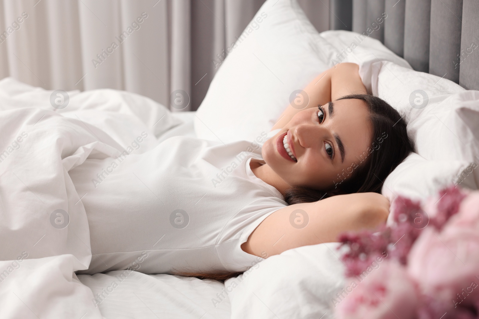 Photo of Happy woman in bed at home. Lazy morning