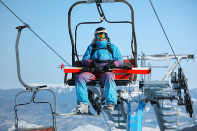 Man using chairlift at mountain ski resort. Winter vacation