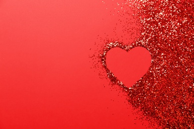 Photo of Heart made of glitter on red background, top view. Space for text