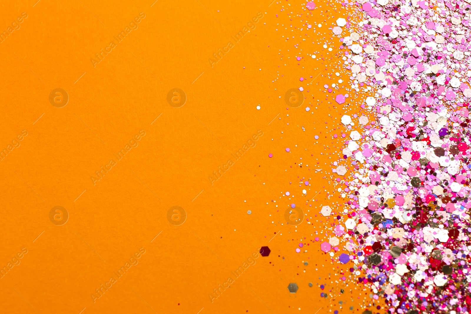 Photo of Shiny bright pink glitter on coral background. Space for text