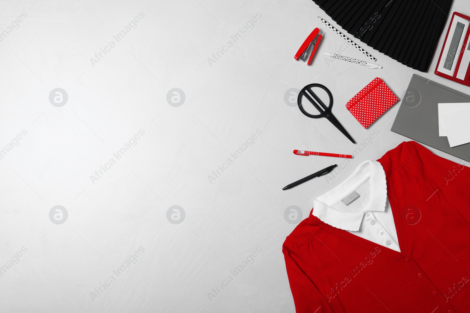 Photo of Flat lay composition with school uniform on light background. Space for text