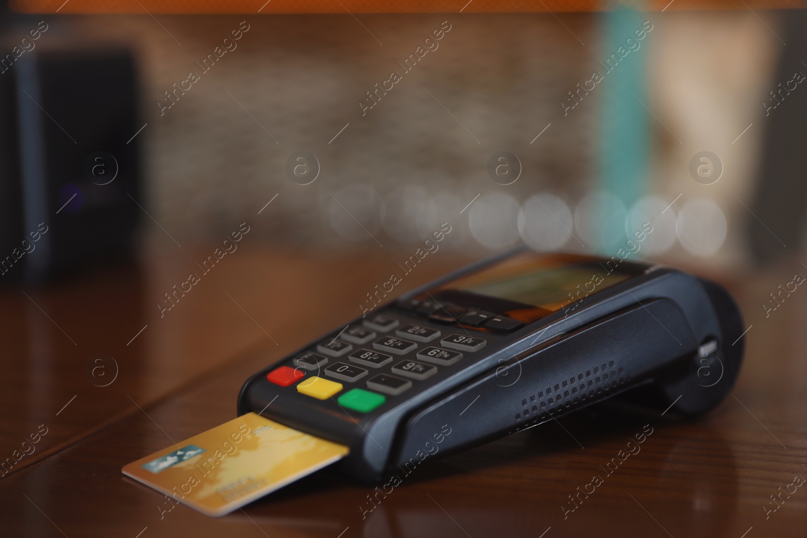 Photo of Credit card machine for non cash payment on wooden counter in cafe