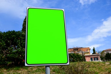 Chroma key compositing. Empty billboard with green screen in city. Mockup for design