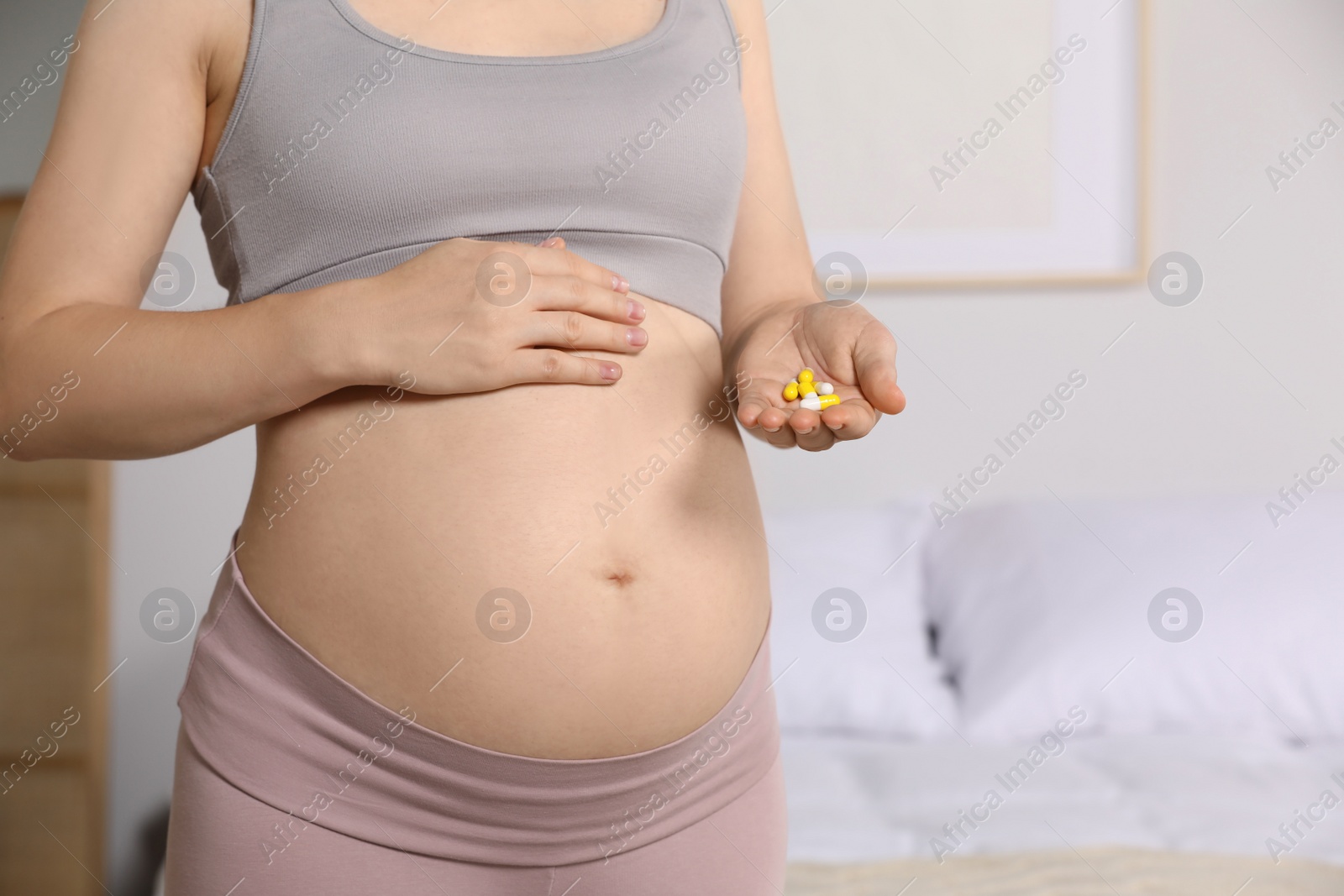 Photo of Pregnant woman taking pills at home, closeup. Space for text