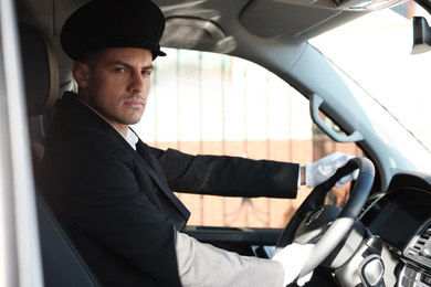 Photo of Professional driver in luxury car. Chauffeur service