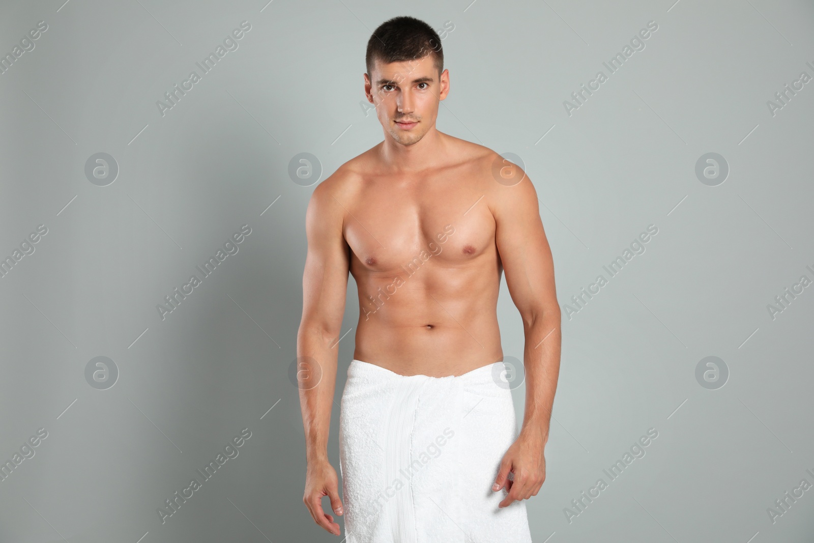 Photo of Young man with slim body on grey background