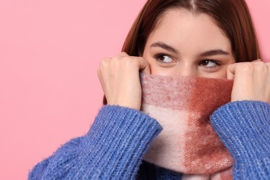 Photo of Beautiful woman in warm scarf on pink background, space for text