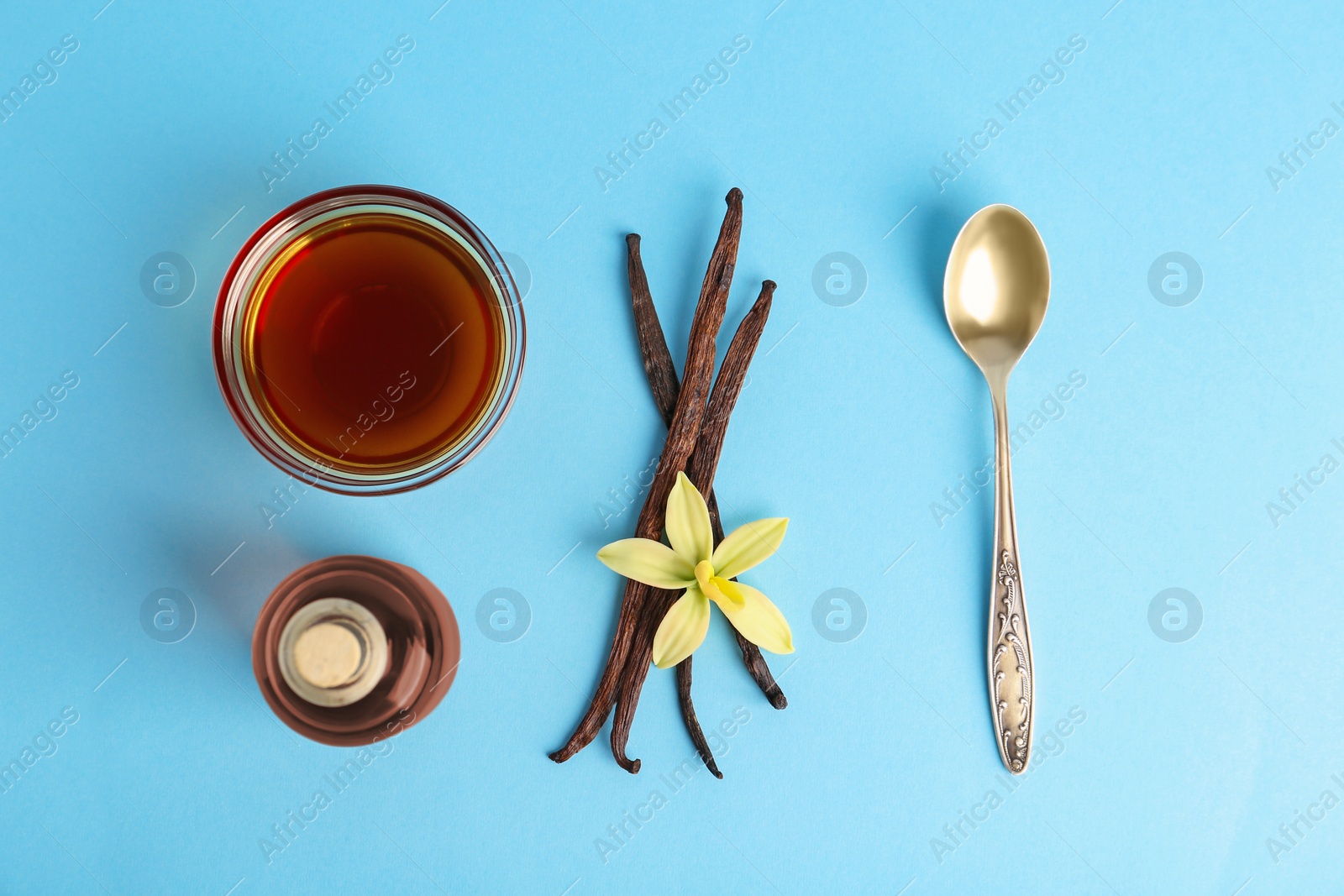 Photo of Flat lay composition with vanilla extract on light blue background