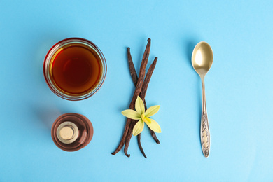 Photo of Flat lay composition with vanilla extract on light blue background