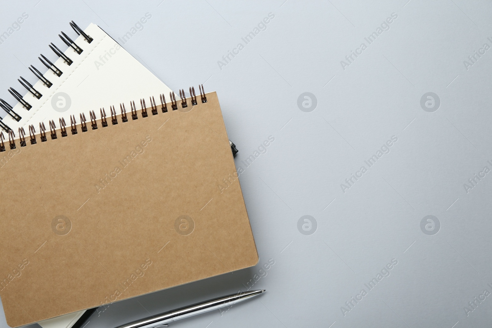 Photo of Notebooks on light grey background, top view. Space for text