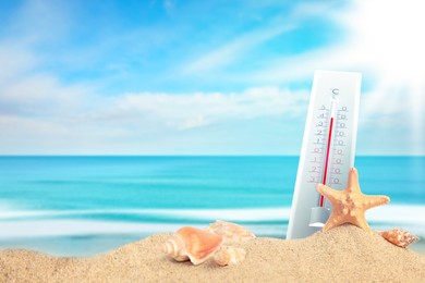 Image of Thermometer on beach showing high temperature during hot day in summer