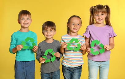 Photo of Children with recycling symbols on yellow background