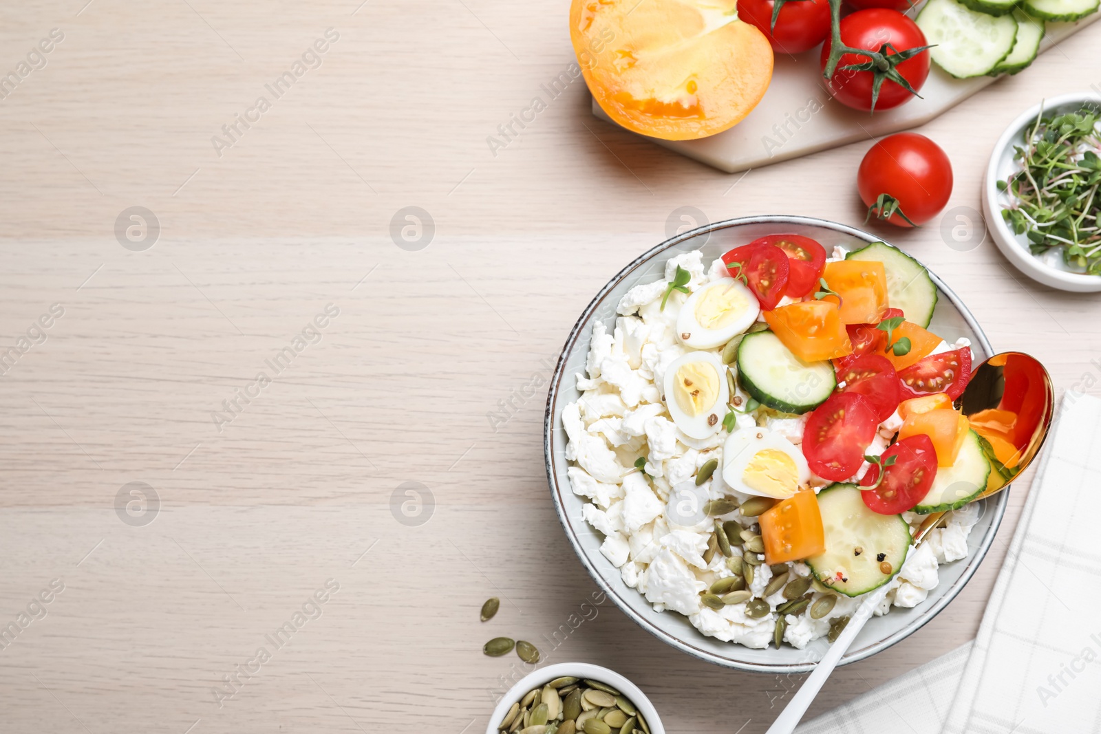 Photo of Fresh cottage cheese with vegetables, seeds and eggs in bowl on wooden table, flat lay. Space for text