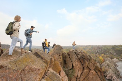 Photo of Group of hikers with backpacks at top of mountain