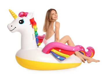 Beautiful young woman in stylish bikini with  unicorn inflatable ring on white background