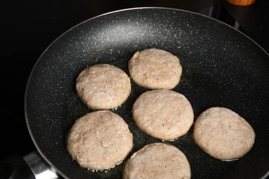 Photo of Cooking vegan nuggets in frying pan on cooktop, closeup