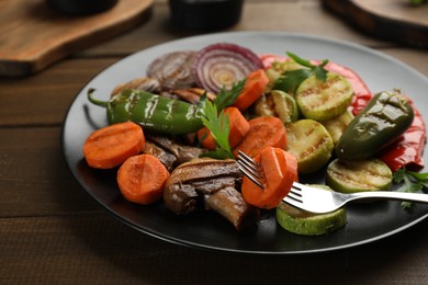 Delicious grilled vegetables with parsley on wooden table, closeup