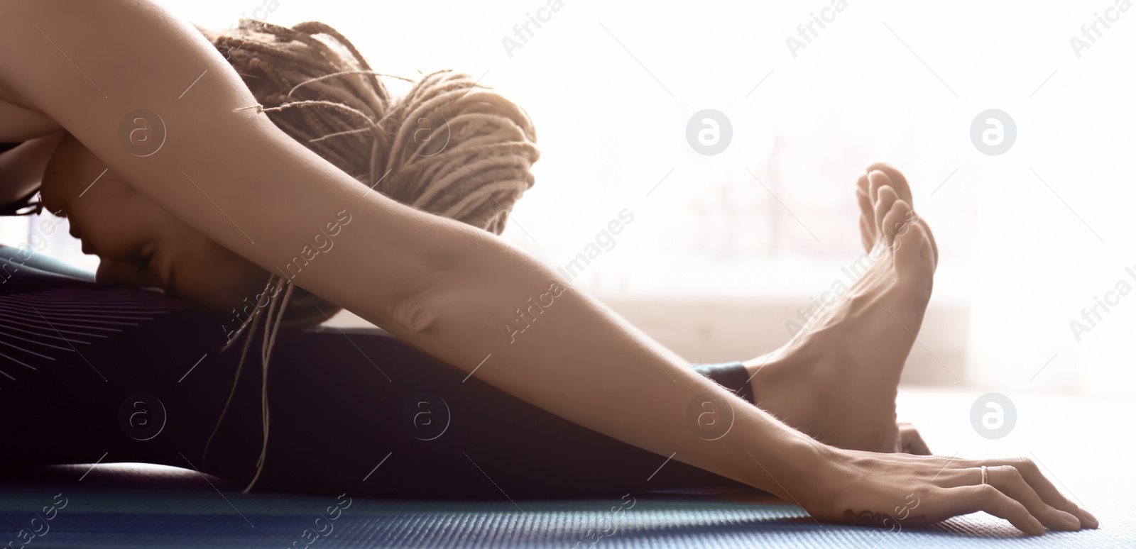 Photo of Young woman practicing yoga indoors