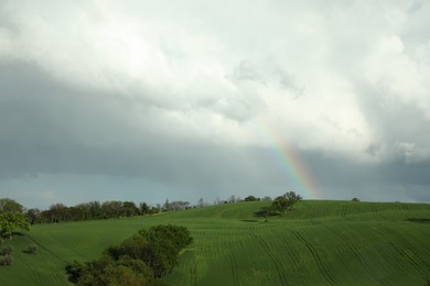 Beautiful view of green field and cloudy sky with rainbow