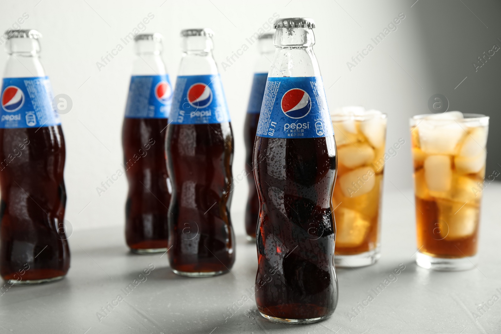 Photo of MYKOLAIV, UKRAINE - FEBRUARY 10, 2021: Bottles and glasses of Pepsi on light table