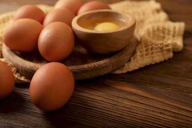 Raw chicken eggs on wooden table, closeup. Space for text