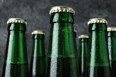 Photo of Bottles of beer on grey background, closeup