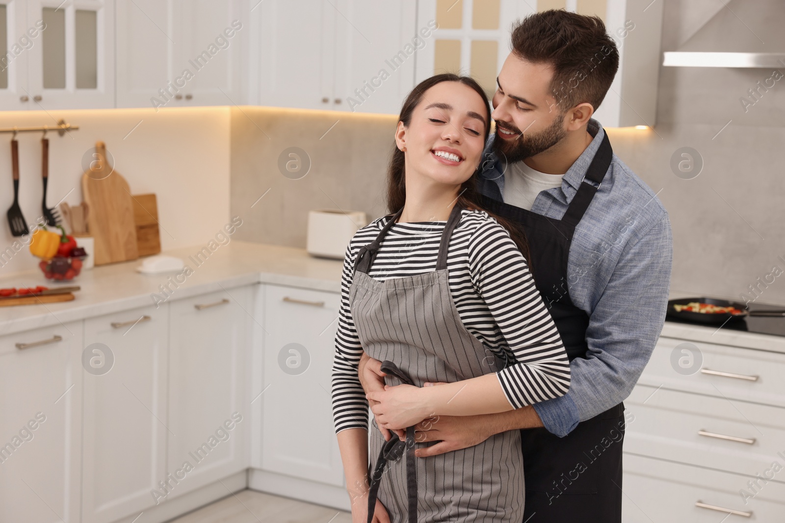 Photo of Lovely couple enjoying time together in kitchen, space for text