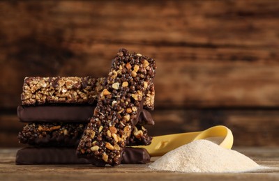 Different tasty bars and protein powder on wooden table