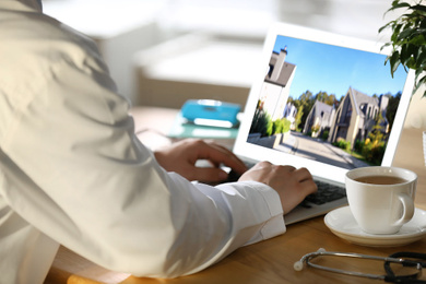 Image of Real estate agency online service. Doctor choosing new house via laptop, closeup