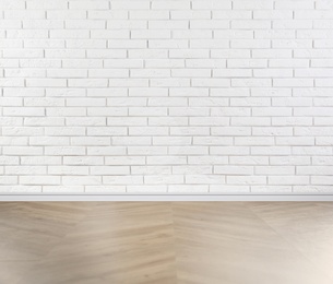 Wooden floor and white brick wall indoors