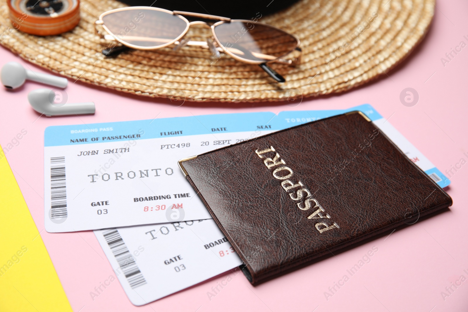 Photo of Passport with tickets near travel items on color background, closeup