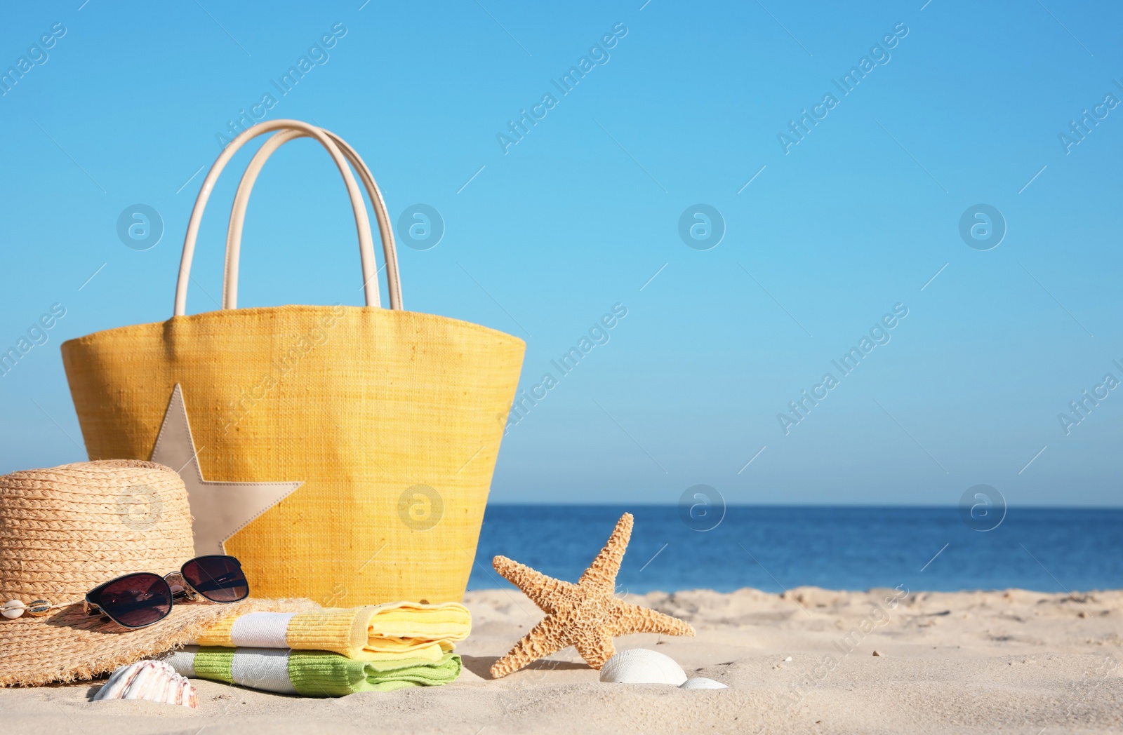 Photo of Bag and beach accessories on seaside. Space for text