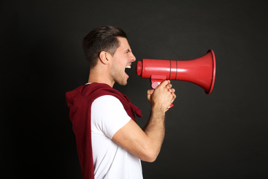 Photo of Handsome man with megaphone on black background