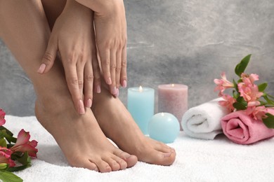 Woman with neat toenails after pedicure procedure on white terry towel, closeup