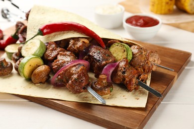 Photo of Metal skewers with delicious meat and vegetables served on white wooden table, closeup