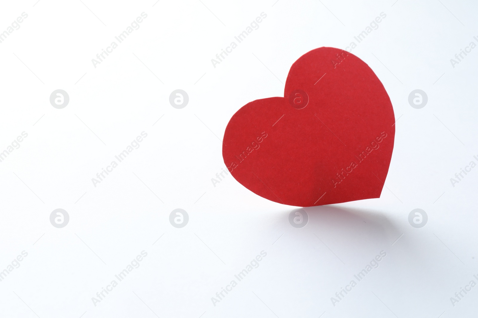 Photo of One paper heart on white background. Space for text