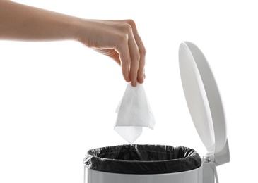 Woman putting paper tissue into trash bin on white background, closeup