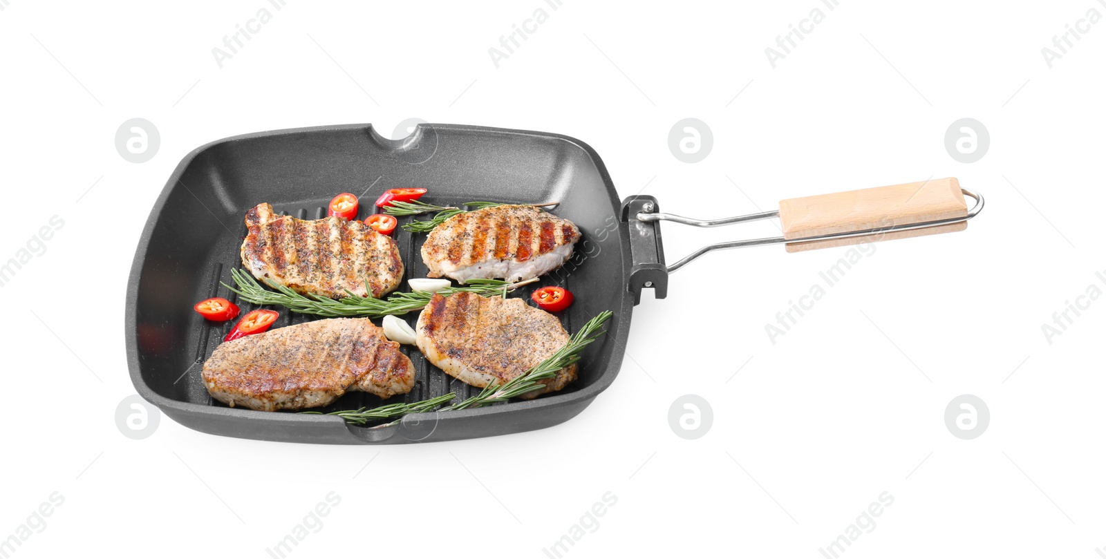 Photo of Grill pan with delicious pork steaks, garlic, chili pepper and rosemary isolated on white