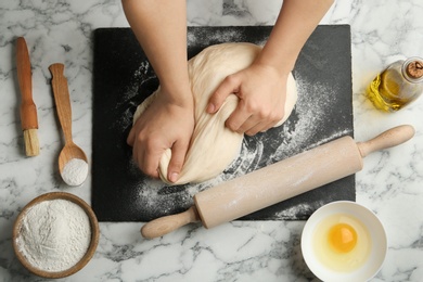 Photo of Female baker preparing bread dough at kitchen table, flat lay