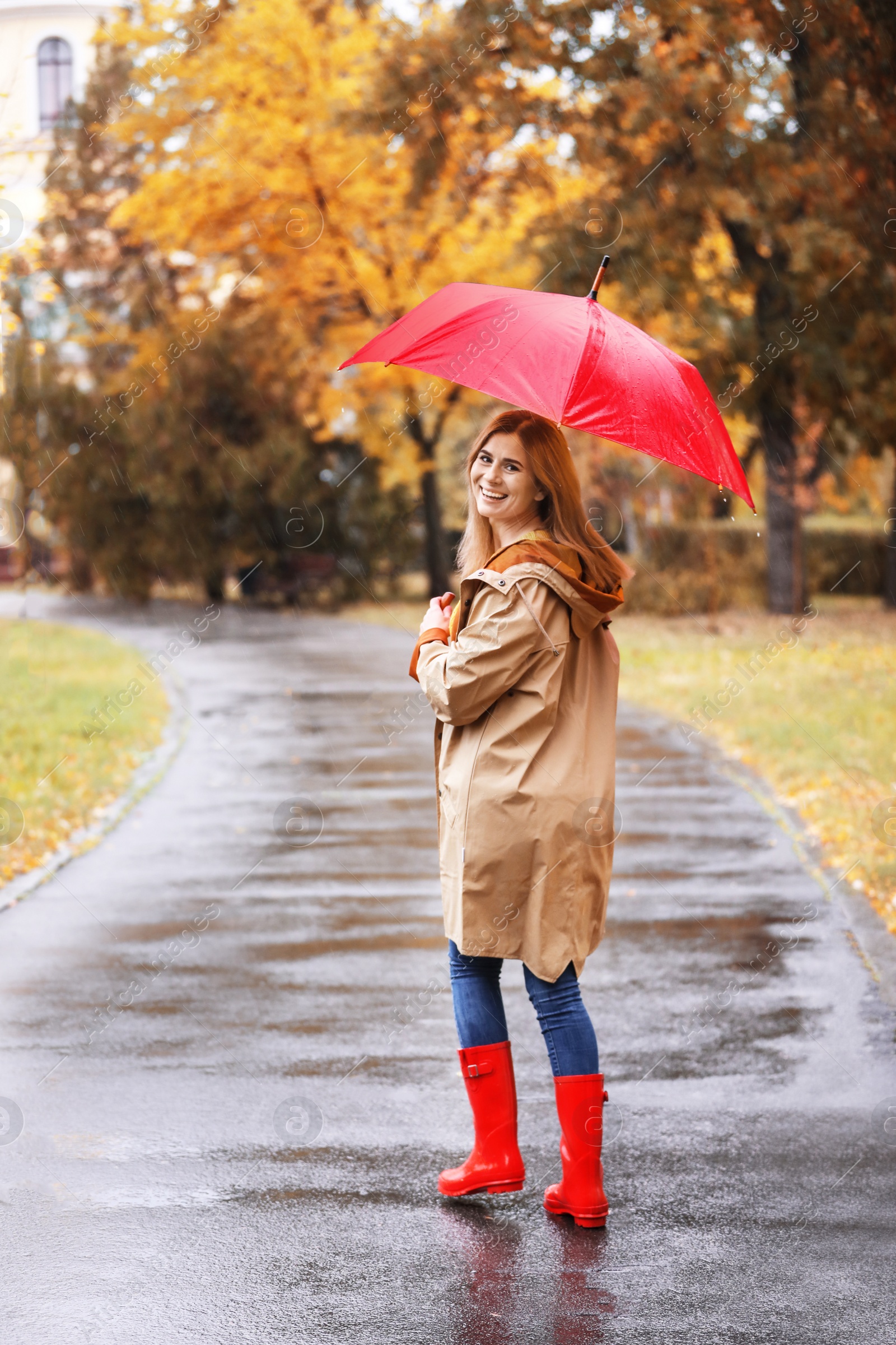 Photo of Woman with umbrella taking walk in autumn park on rainy day