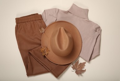 Flat lay composition with stylish hat and clothes on beige background